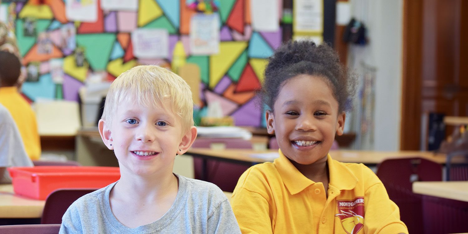 Two smiling students seated in a classroom.
